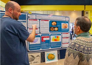 Two men looking at a poster display